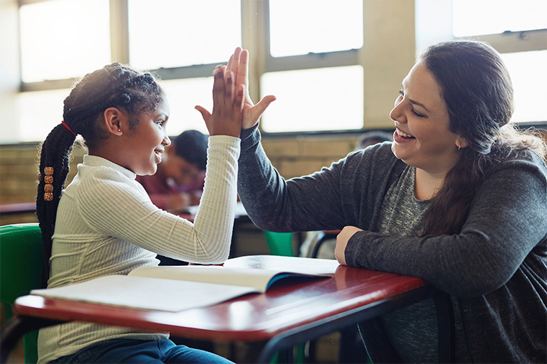 Teacher and student high fiving