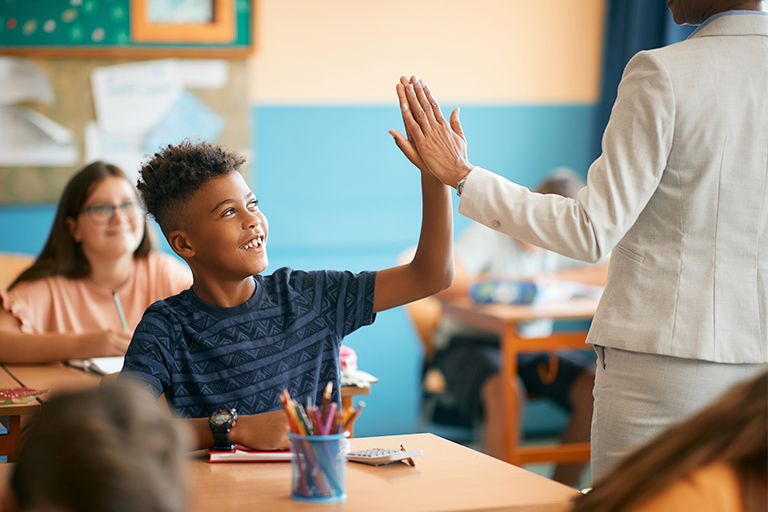 Student and teacher high fiving after conquering math intervention implementation